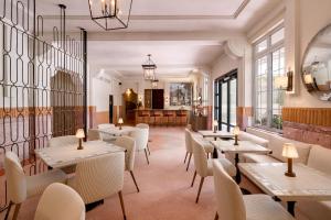 a restaurant with tables and chairs and windows at Liberty Park Hotel South Beach in Miami Beach