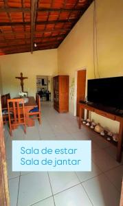 a living room with a table and a piano at Casas de Praia do Coqueiro com AR e varandas in Luis Correia