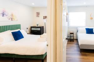 a bedroom with a bed with blue and white pillows at Spacious 2-Bedroom Apartment NYC-10 mins away in Union City