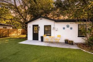 a white house with a table and chairs in a yard at NEW Beach Cozy Bungalow 2B Mins-beach&downtown in Clearwater