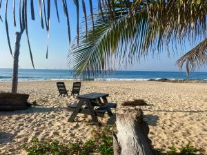 a picnic table and two chairs on a beach at Beachfront - Private Floor, 4 Rooms - Casa 3 Lunas in Playa Agua Blanca