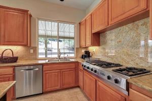 a kitchen with wooden cabinets and a stove and a window at Beautiful Villa with Amazing 360 Mountain Views, Golfcourses close to Monserate Winery and I-15 in Fallbrook