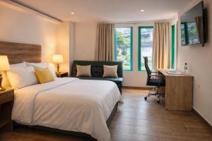 a hotel room with a bed and a desk and a chair at Durán Business Suites near Airport in Bogotá