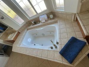 a large bath tub in a bathroom with a blue towel at Beautiful Villa with Amazing 360 Mountain Views, Golfcourses close to Monserate Winery and I-15 in Fallbrook +38 photos