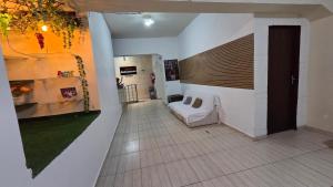 a living room with a bed in a room with a wall at Hotel Embaixador de Curitiba in Curitiba