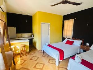 a hotel room with two beds and a kitchen at Posada el Sol in El Cuyo
