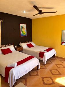 a bedroom with two beds and a ceiling fan at Posada el Sol in El Cuyo