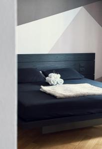 a bedroom with a bed with a black headboard at Paponena Holidays in Riva del Garda