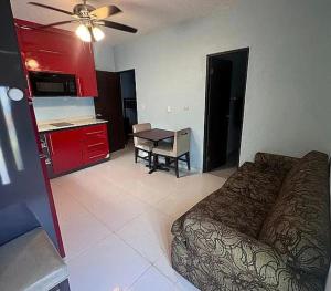 a bedroom with a bed and a table and a kitchen at Puntilla Aparments in Catano