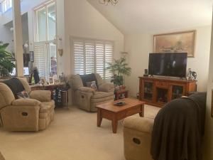 a living room with couches and a flat screen tv at Hosts offer Single Bed accommodation to Suit Single Travellers in Swan Hill