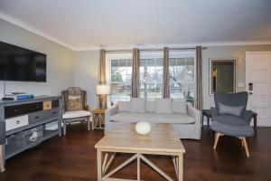 a living room with a couch and a tv at Dorchester Cottage in Niagara-on-the-Lake