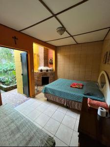 a bedroom with a bed and a bathroom with a fireplace at HOSTAL CABAÑAS AVE MARIA in Concepción de Ataco