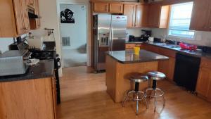 a kitchen with a stainless steel refrigerator and bar stools at Kings Private Room Shared Bath C in Decatur