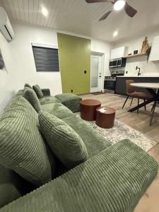 a living room with a green couch and a kitchen at Josie Cozy Corner in Grand Turk
