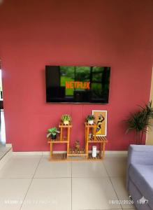 a living room with a tv on a red wall at Green Leaf House in Fortuna