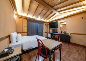 a hotel room with a bed and a desk and a table at Hotel Petit Gimpo in Gimpo