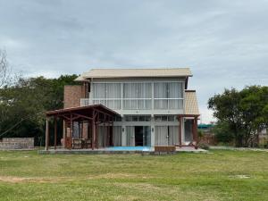 a large house with a gazebo in a field at Apartamento de frente para lagoa -Ap 101 in Laguna