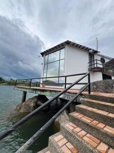 a building with glass windows next to the water at Afrodita Chalet in El Peñol