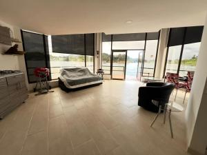 a bedroom with a bed and chairs in a room with windows at Afrodita Chalet in El Peñol