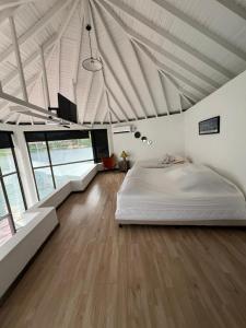 a bedroom with a white bed in a room with windows at Afrodita Chalet in El Peñol