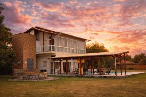 a large house with a sunset in the background at Apartamento de frente para lagoa -AP 102 in Laguna