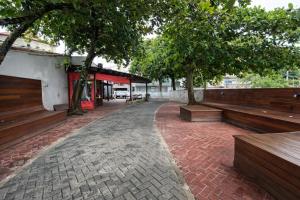 a sidewalk with benches and trees and a building at Meu Point Itauna 1 - Paraíso a 50 Metros do Mar in Saquarema