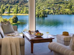 a room with a table with a bowl of fruit and wine glasses at Solitaire Lodge in Rotorua +16 photos