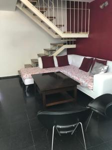 a room with a couch and a table and stairs at Duplex SM con ESTACIONAMIENTO in San Juan