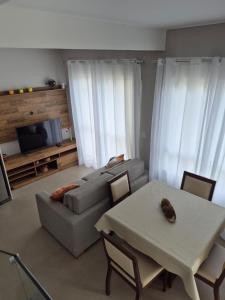 a living room with a couch and a table at Sobrado com Arcondicionado, tomada 220V para veículo elétrico e Wi-Fi em Coroados Guaratuba in Guaratuba