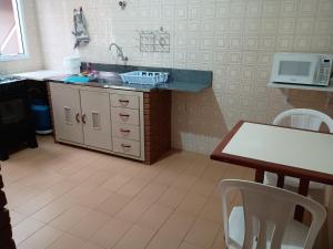 a kitchen with a sink and a table with chairs at Casa Tapajos in Ubatuba +12 photos