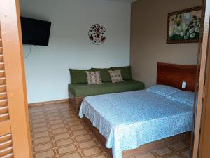 a small bedroom with a bed and a couch at Casa Tapajos in Ubatuba