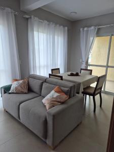 a living room with a couch and a table at Sobrado com Arcondicionado, tomada 220V para veículo elétrico e Wi-Fi em Coroados Guaratuba in Guaratuba