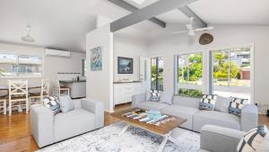 a living room with two couches and a table at Port View on the Peninsula in Lemon Tree Passage
