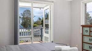 a bedroom with a bed and a large window at Port View on the Peninsula in Lemon Tree Passage