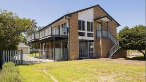 a brick house with balconies and a yard at Port View on the Peninsula in Lemon Tree Passage