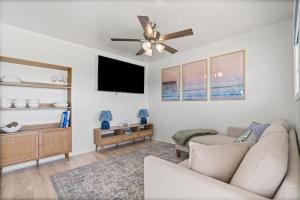 a living room with a couch and a ceiling fan at High Point Hideaway on the Sand Dunes - Unit 2 in Dauphin Island