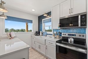 a kitchen with white cabinets and a stove top oven at High Point Hideaway on the Sand Dunes - Unit 2 in Dauphin Island