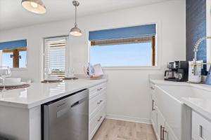 a kitchen with white counters and a window at High Point Hideaway on the Sand Dunes - Unit 2 in Dauphin Island +14 photos
