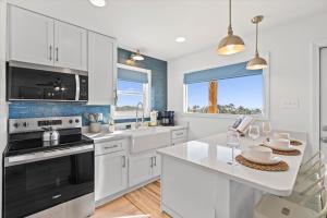 a kitchen with white cabinets and a white counter top at High Point Hideaway on the Sand Dunes - Unit 3 in Dauphin Island