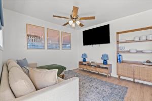 a living room with a couch and a flat screen tv at High Point Hideaway on the Sand Dunes - Unit 3 in Dauphin Island