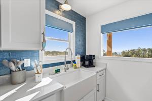a white kitchen with a sink and a window at High Point Hideaway on the Sand Dunes - Unit 3 in Dauphin Island +15 photos