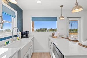 a white kitchen with a sink and a window at High Point Hideaway on the Sand Dunes - Unit 3 in Dauphin Island