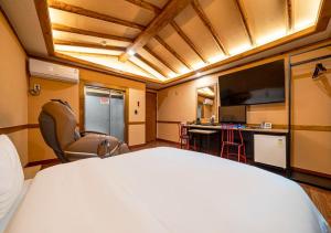 a hotel room with a bed and a desk and a tv at Hotel Petit Gimpo in Gimpo