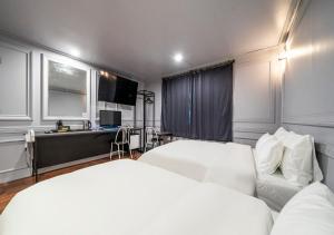a bedroom with two beds and a couch in it at Hotel Petit Gimpo in Gimpo +43 photos