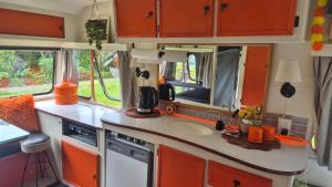 a kitchen with a counter and a sink in an rv at Boutique Retro Caravan in Westport +2 photos