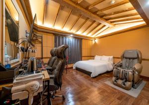 a hotel room with a bed and a desk with a computer at Hotel Petit Gimpo in Gimpo