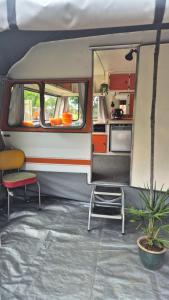 a caravan with a table and a chair and a kitchen at Boutique Retro Caravan in Westport