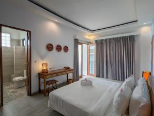 a bedroom with a bed and a desk and a window at Lay Day Gili T in Gili Trawangan +46 photos