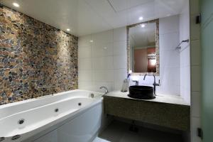 a bathroom with a tub and a sink and a mirror at Amant Hotel in Goyang +44 photos