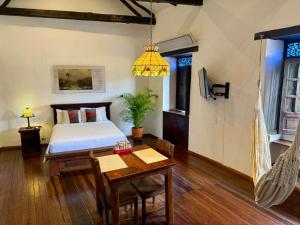 a bedroom with a bed and a table and a hammock at Casa Aranjuez in Bogotá